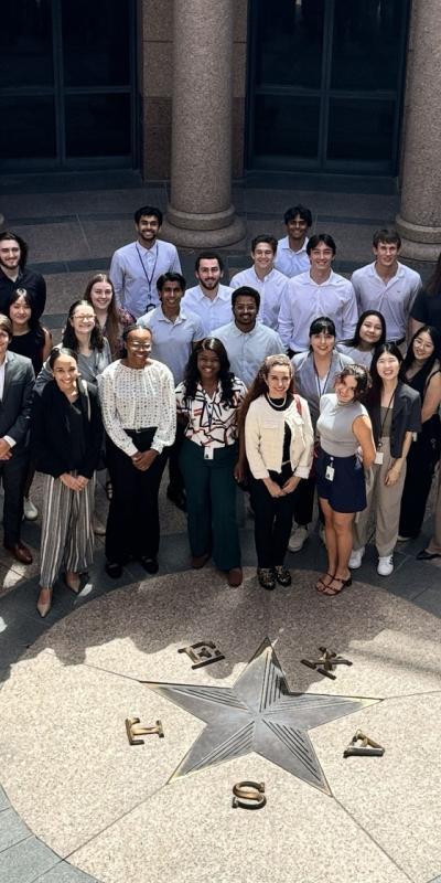 group of interns pose in front of Texas capitol
