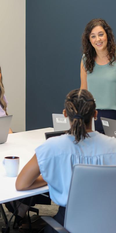 seven employees meet around a large conference table