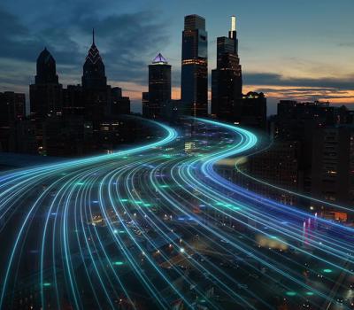 busy traffic leads in to city skyline at night