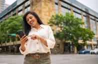 a woman scans her mobile phone while outside