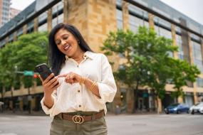 a woman scans her mobile phone while outside