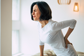 woman grabs back in pain