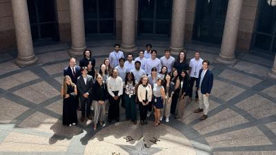 group of interns pose in front of Texas capitol