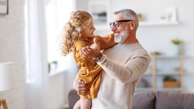 grandfather dances with young grandaughter