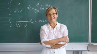 professor in front of chalkboard with math equations