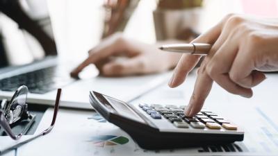 hand taps calculator on desk