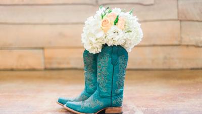teal cowboy boots with bouquet of white flowers