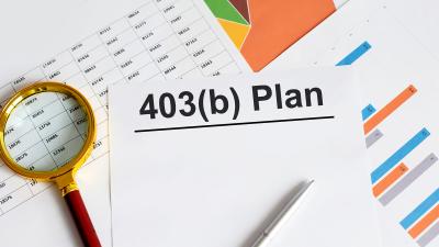 magnifying glass and papers on desk that say 403b plan