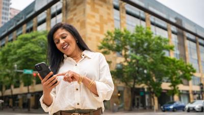 a woman scans her mobile phone while outside
