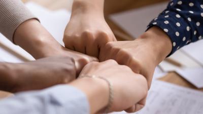 five hands tap as a group gesture of unity