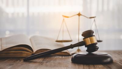law book, wooden gavel and scales of justice