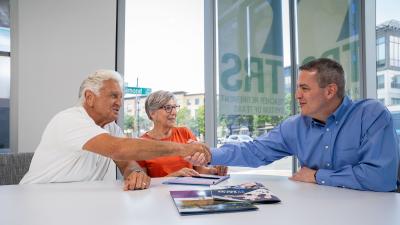 retiree couple meets with counselor in bright office