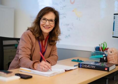 teacher grades papers at her desk