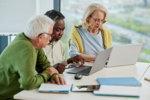 retirees meet with books and laptops