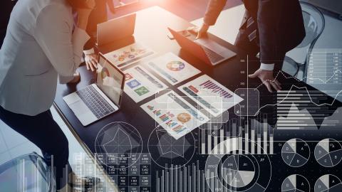 team of staff review colorful charts on a desk