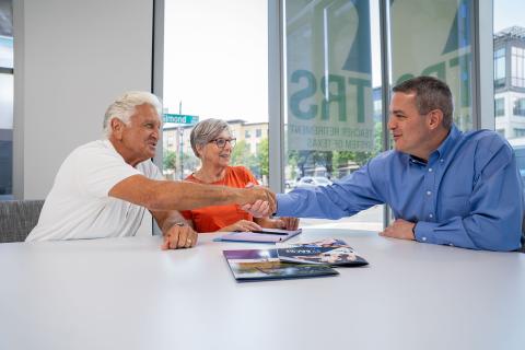 retiree couple meets with counselor in bright office
