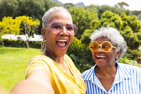 two senior women in glasses smiling