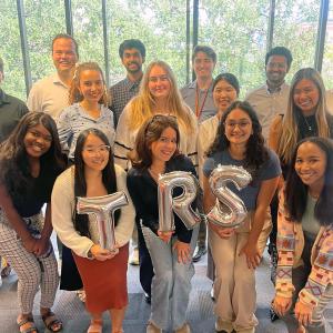group of coworkers pose with TRS balloons