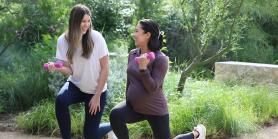 a pregnant woman and another women stretch while holding weights