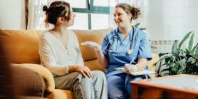 Patient and nurse talking while sitting on couch