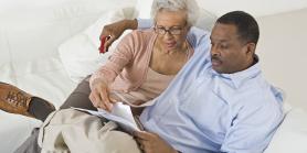 couple on sofa reviewing papers together