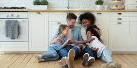 family of four sitting on kitchen floor