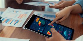 hand holds tablet with many charts and tables