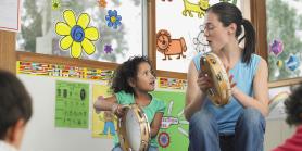 kindergarten teacher and child play musical instruments