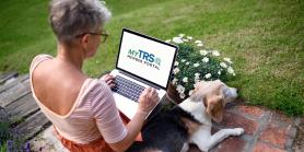 woman with dog sits on porch viewing laptop