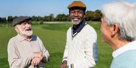 male friends talking and laughing on golf course