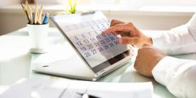 man's hand taps on desktop tablet with calendar