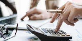 hand taps calculator on desk