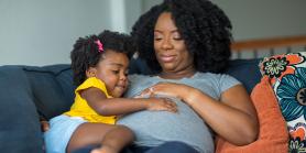 pregnant mother rest on sofa with toddler