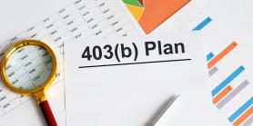 magnifying glass and papers on desk that say 403b plan