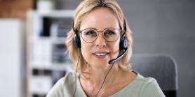 woman with headset smiles into camera