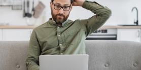 puzzled man looks at laptop screen