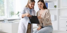 young woman reviews medical report with doctor