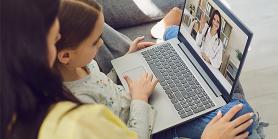 mother and daughter talk to doctor on virtual visit with laptop