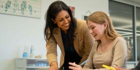 teacher helps young female student with papers