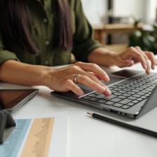 female hands type on laptop keyboard