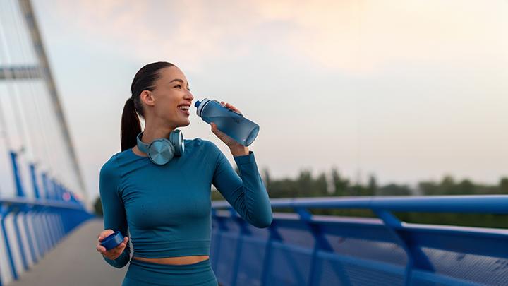woman drinking from water bottle