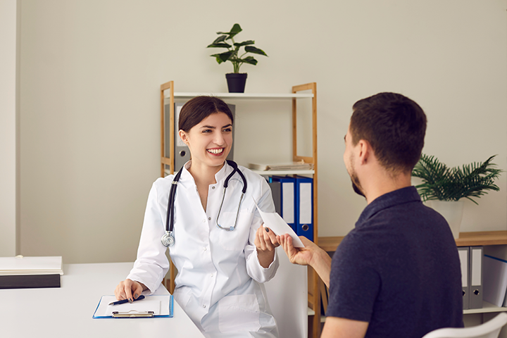doctor hands paper to patient