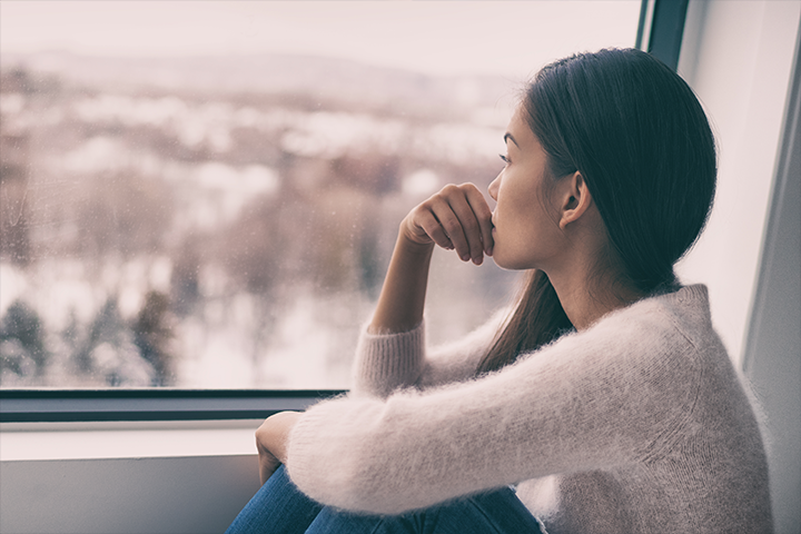 sad woman looks out window
