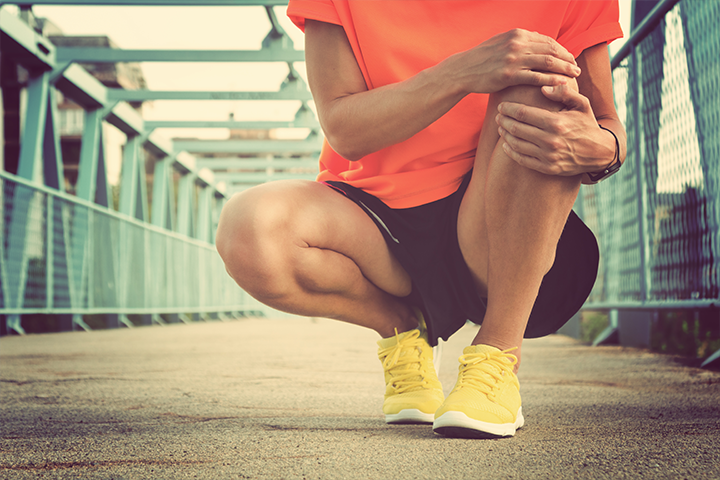 runner crouching down holding knee