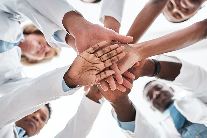 doctors’ hands in huddle