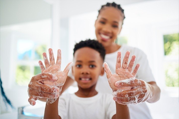 mom helping son wash hands