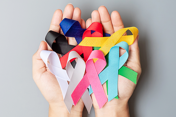 hands holding cancer ribbons