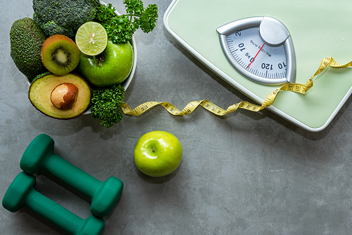 scale, hand weights, tape measure and bowl of fruit