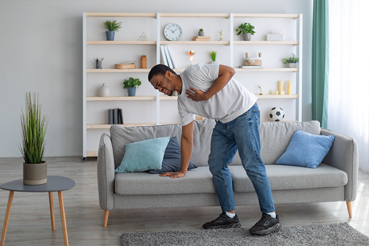 man bending down and grabbing chest