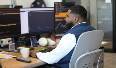 investor seated while working with a computer at his desk